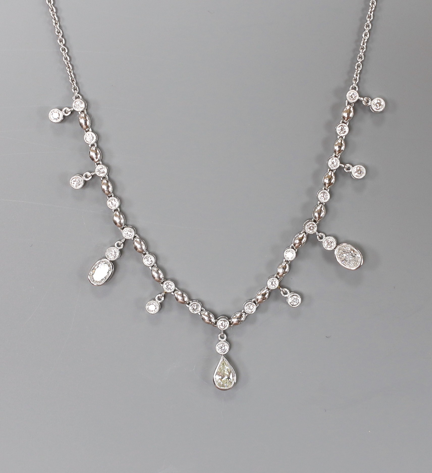A modern 750 white metal and diamond cluster set drop fringe necklace, 42cm, gross weight 11.8 grams